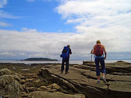 pair of hikers in Mary's Point, New Brunswick, overlooking Grindstone Island in the Bay of Fundy
